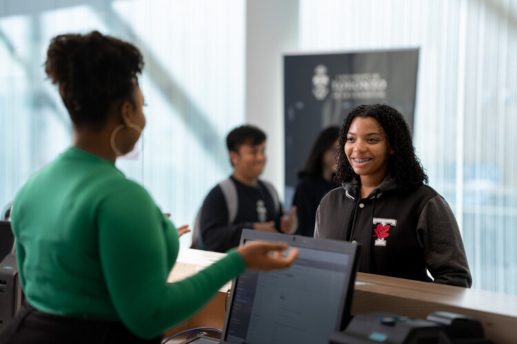 A person talking to another person at the reception desk